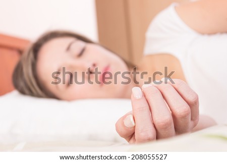 Pretty blond girl sleeping with extended hand selective focus