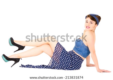 Beautiful young woman dressed in retro blue clothes lying on the floor posing isolated on white