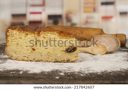 delicious piece of vanilla cake and cooking spoons decorated with caster sugar on a wooden table