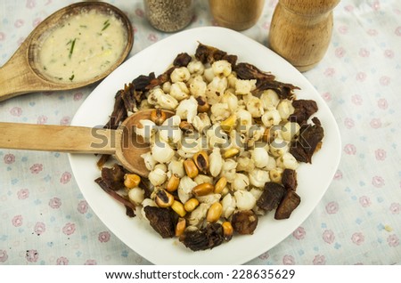 hominy and toasted corn nuts with pork skin with aji sauce on wooden spoon  mote con chicharron traditional ecuadorian food