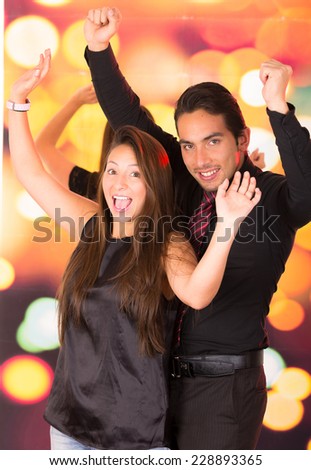 happy latin young couple dressed in black dancing in a nightclub