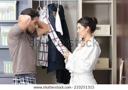 married young couple choosing arguing about clothes in the closet