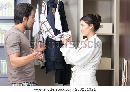 married young couple choosing arguing about clothes in the closet