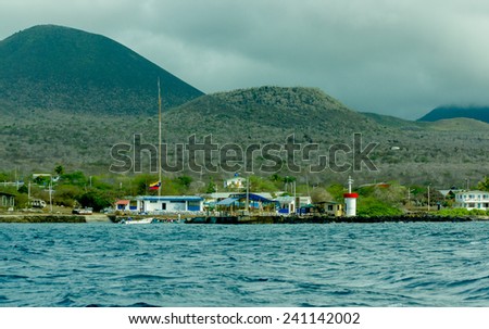 floreana island bay with mountains and gray sky on background