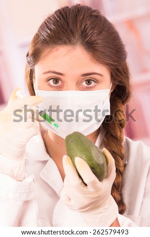 young beautiful female biologist experimenting with avocado in lab concept of genetically modified food