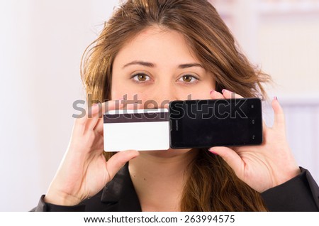 modern beautiful young woman holding cell phone and credit card concept of online shopping, phone purchase