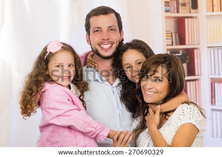 Sweet family with two little girls happily posing