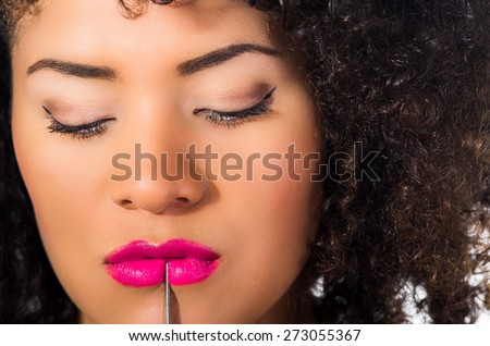 close up shot of beautiful exotic young tribal woman holding a dagger against her lips and chin