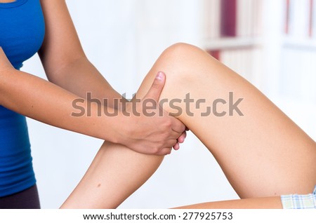 young woman lying while getting a leg massage from specialist concept of physiotherapy. Close up