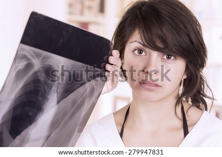 Beautiful young girl looking nervous shile doctor checks xray
