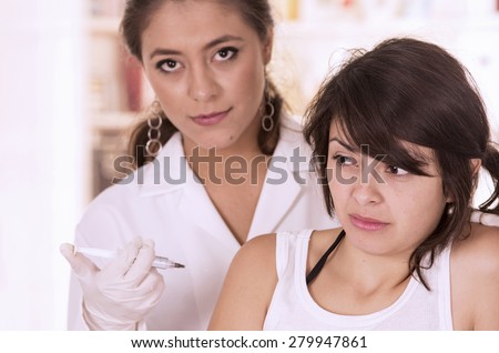Young afraid girl patient getting a shot by nurse