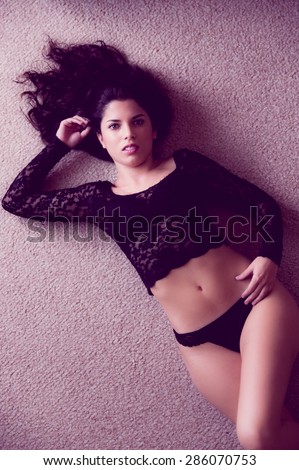 from above angle of pretty girl lying down on carpet wearing panties and sexy top posing sexy touching hair