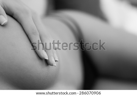sexy unknown woman with thong covering breast with her hand from above frontal angle black and white