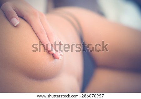 sexy unknown woman with thong covering breast with her hand from above frontal angle