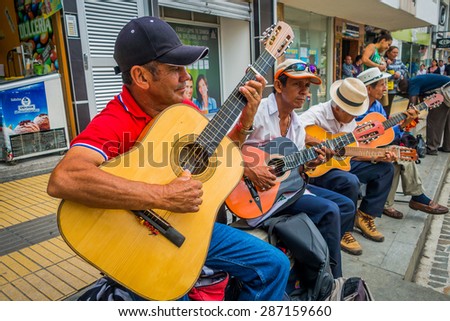 ARMENIA, COLOMBIA - FEBRUARY 23, 2015: Unidentify indigenous men playing guitar in the commercial street of Armenia, Colombia