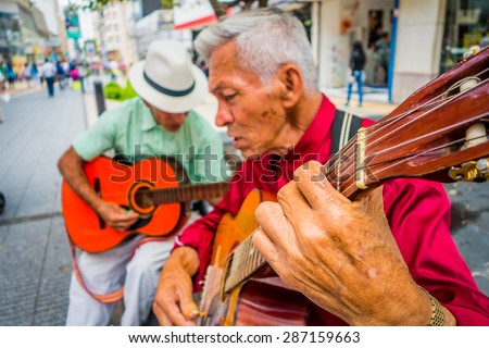 ARMENIA, COLOMBIA - FEBRUARY 23, 2015: two unidentify indigenous men playing guitar in the commercial street of Armenia