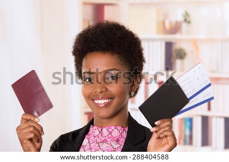 Black office woman holding up tickets and passport document smiling concept transport airplane airline bus train traveling airport counter depart flight
