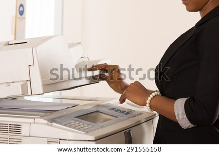 Black office womans hand pressing buttons on a copy machine