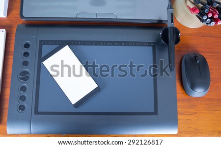 White mobile phone laying on digital drawboard facing down