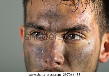 Closeup hispanic man dirty face eyes and nose caption looking to the side.