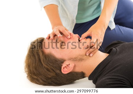Closeup of unconscious male head and female hands holding his nose plus opening mouth with other hand.