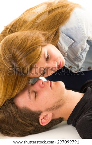 Couple demonstrating first aid techniques with female helper placing her ear over patients mouth listening.