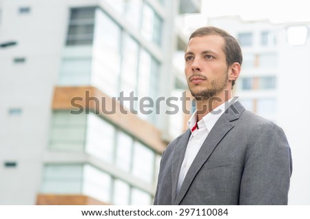 Man formal clothing in urban environment looking forward concentrated shot from front side angle.