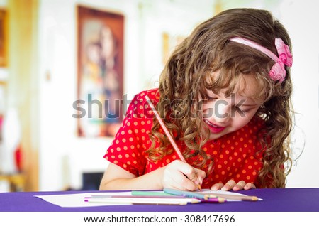 Sweet preschooler creative girl using colored pencils, drawing
