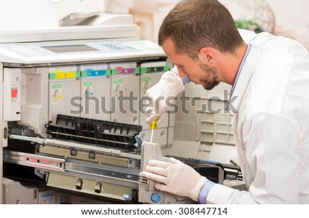 closeup shot young male technician repairing digital photocopier machine