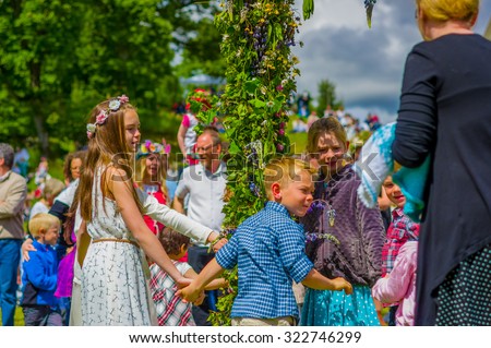 GOTHENBURG, SWEDEN - JUNE 19, 2015: Cheerful people dancing around the maypole during Midsummer celebration in Gunnebo Castle
