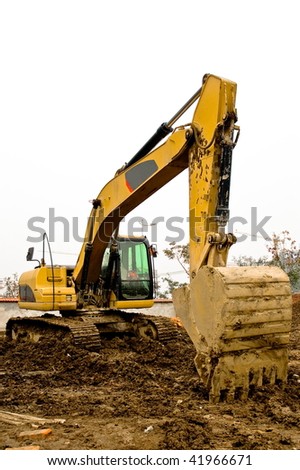Yellow and black dirty excavator parked on the construction site.