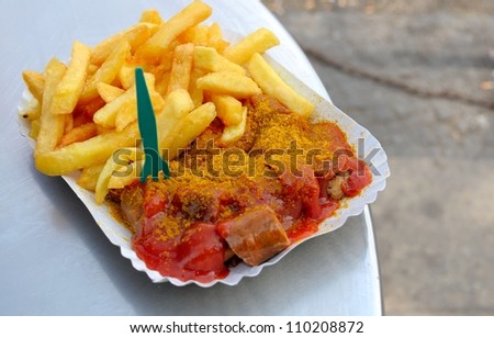 Currywurst, pork sausage cut into slices and french fries with curry sauce