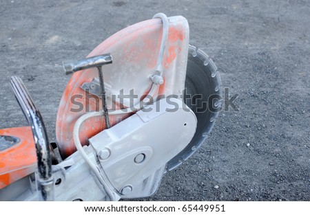 Construction machine used for cutting through concrete or tarmac roads. Focus on blade