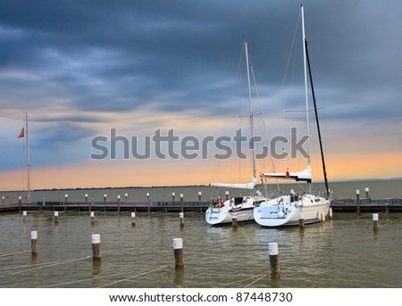 Stormy sunset with two yachts in marina