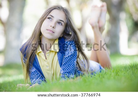 Portrait of Tween Girl Lying on Grass Looking up to Sky