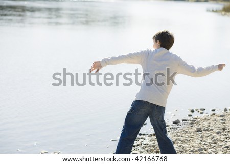 Young Boy Throwing Stones in a River