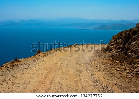 Mediterranean sea and gravel dangerous road, which leads to Gramvousa beach on island of Crete in Greece