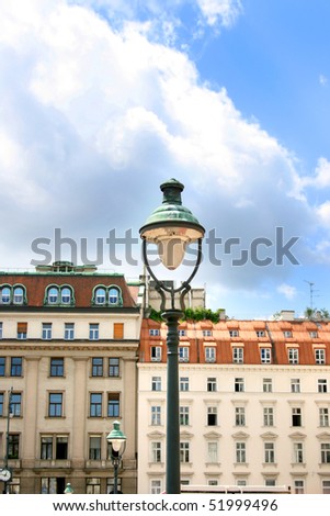 Architecture of modern Vienna in Austria. An old lamp in the first plan against beautiful sky.
