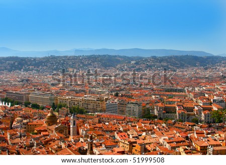 Cityscape of Luxury resort of French riviera. Beautiful panorama city of Nice in France. Sunny, summer day near Mediterranean sea, churches, houses and famous red tile roofs of Nice.