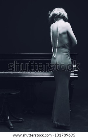 beautiful young attractive woman in evening dress and piano (black and white shoot)