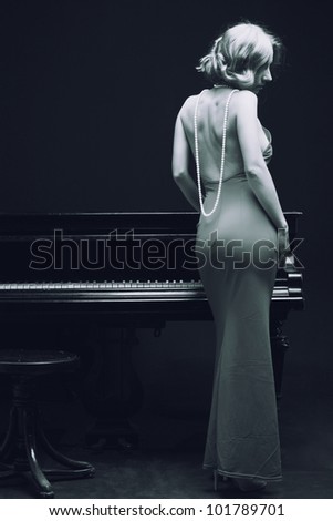 beautiful young attractive woman in evening dress and piano (black and white shoot)