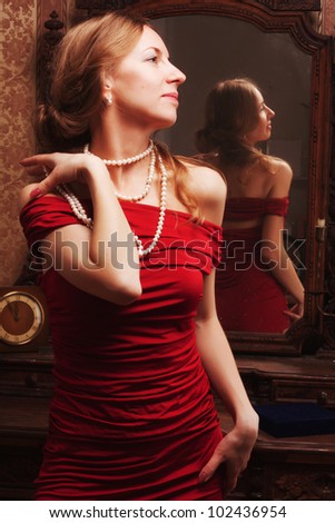 beautiful young woman looks at the reflection in the mirror in the