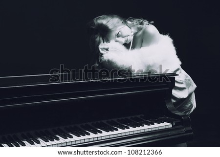 Beautiful young attractive woman in cocktail dress and piano