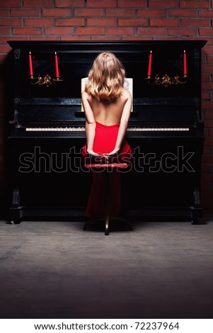 beautiful young woman in red dress playing the piano