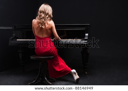 beautiful young attractive woman in cocktail dress and piano