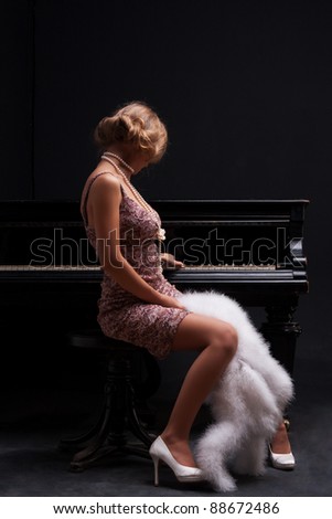 beautiful young attractive woman in cocktail dress and piano
