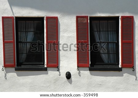 two windows with brown shutters