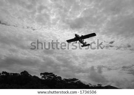 Black and white photo of small plane taking off against a threatening sky