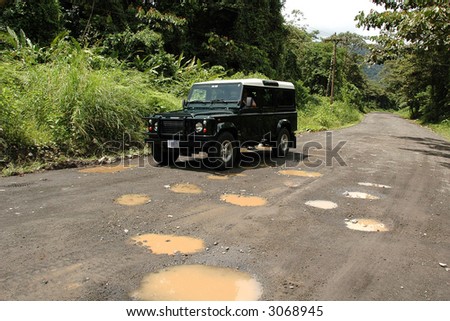 SUV on badly pot-holed road in Costa Rica