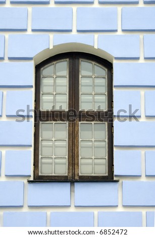 Arched window on a blue brick wall